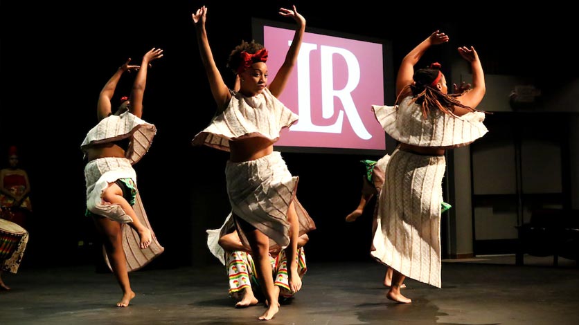 Students dancing on stage at event