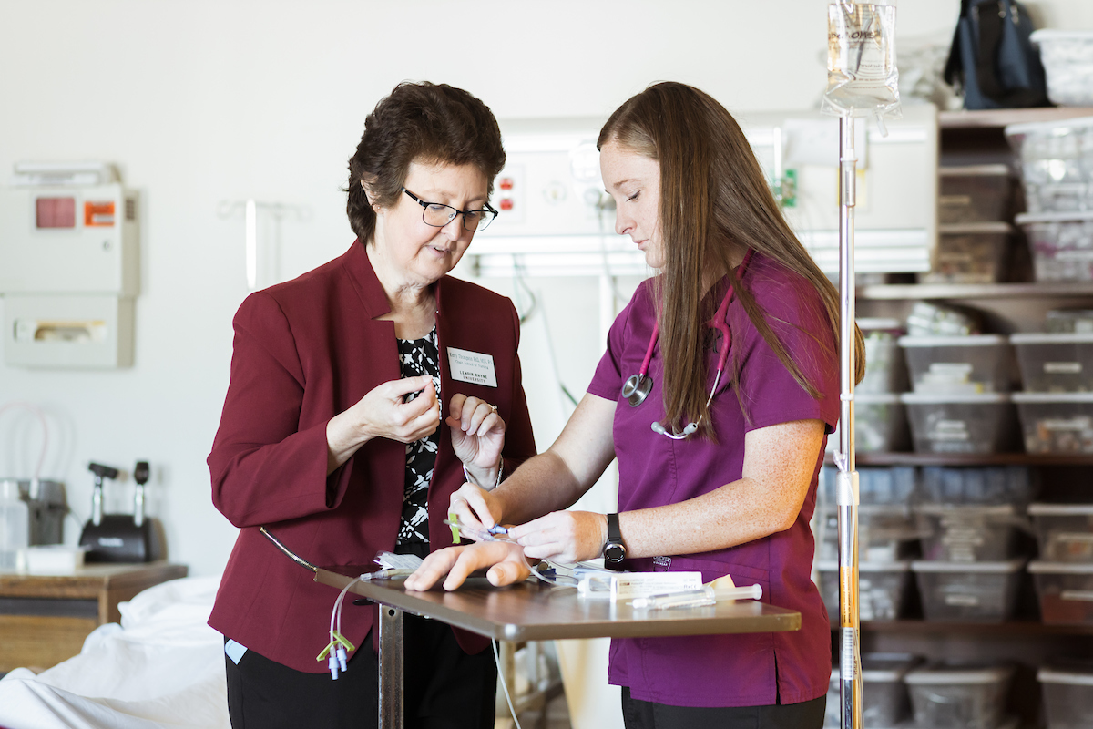 Hannah Fowler, right, works in a nursing lab with a faculty member, left