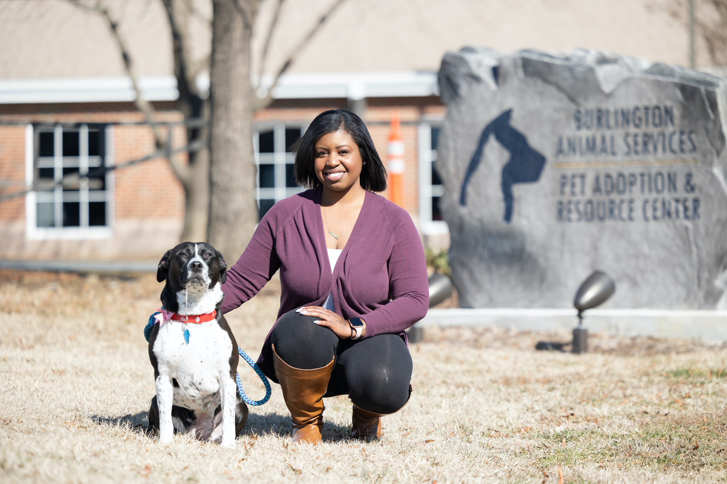 Amber Currie kneels outside of the an animal shelter with her dog