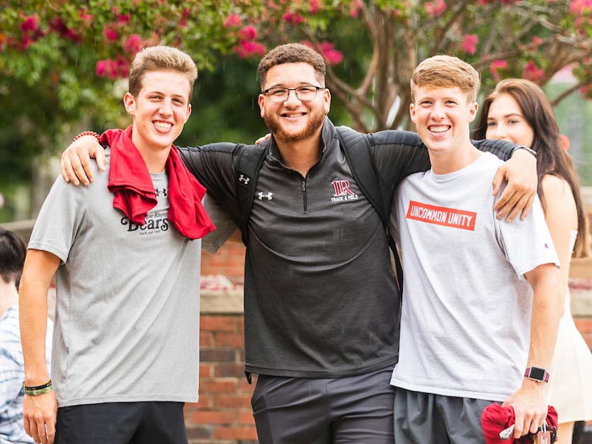 Three smiling students pose for a group photo