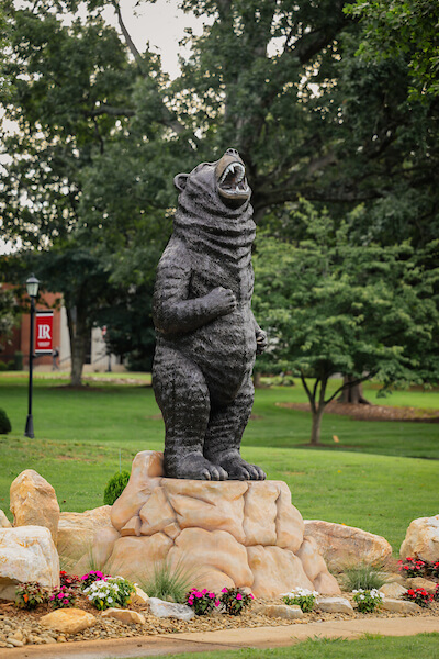 Standing bear sculpture with flowers