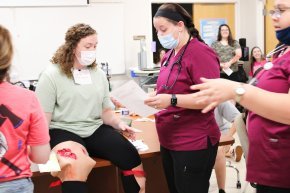 Student nurses work with classmates as part of a disaster simulation