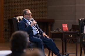 Michael Eric Dyson sits in a chair on a stage