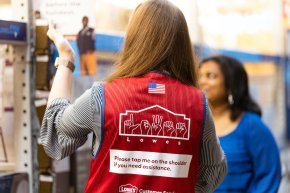 A person wearing a red vest with their back to the camera