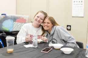 Two students look at the camera and smile