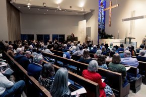 People sit in a chapel in the evening