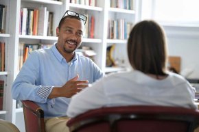 Professor talks with student in office