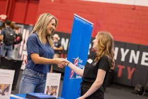 A student shakes hands with a representative from First Citizens at Success Fest 2023