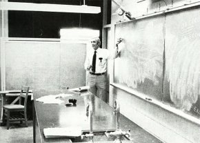 Charles Cooke in front of a chalkboard in the lab in 1984