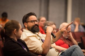 An alumnus with a beard asks a question during the session in Belk Centrum