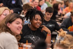 Students sit around a table in the cafeteria to take part in Final Flip