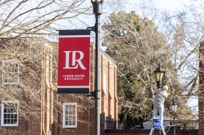 Banners on light posts along the quad by Mauney-Schaeffer during installation in late spring