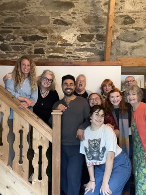 Laura Hope-Gill with friends, family and student travel companions posing on a staircase in a Scottish cottage