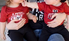 Two toddler girls sit on their moms lap