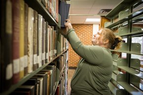 Lillian Cummines shelves books in Rudisill Library