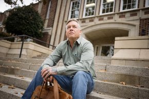 Eric Dunaway sits on the steps of the Rhyne Building