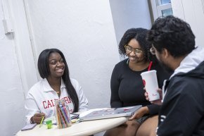 Three students gather around a table in the Clemmer-Long Center for Vocation and Purpose