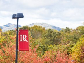 An LR banner hangs from a lamppost outside with the mountains in the background