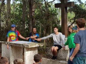 Students stand outside and hold hands while praying