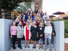 A group of people stand on stairs outside