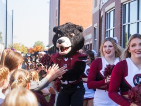 Joe Bear gives high fives to kids outside Moretz Stadium