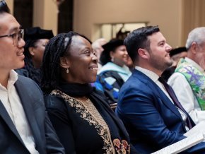 Lillian Okoronkwo sits in a church pew amongst other congregation members. 