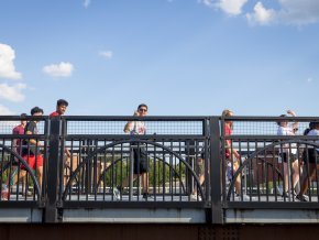 Students walk across a bridge on a sunny day