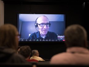 Chad Rimmer appears via Zoom on the large screen at Q&A session in Belk Centrum