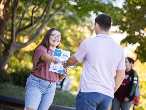 Jocelyn Florez hands out healthcare pamphlets on campus