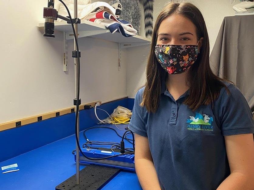 Jillian Petersen in a biology lab with an ultraviolet camera.