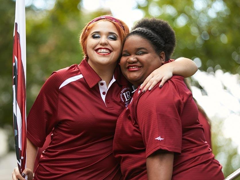 Two members of the band hugging and smiling