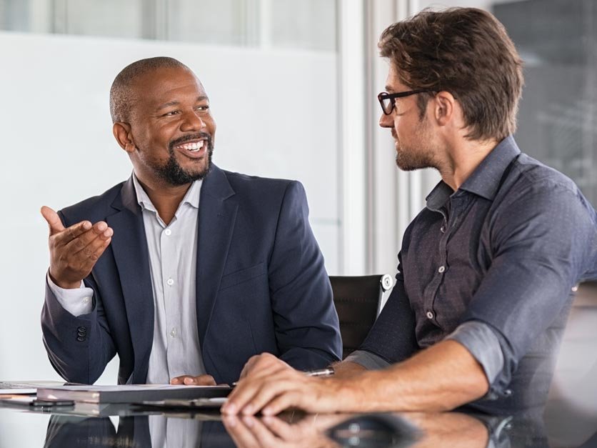 Two students discuss class project at table