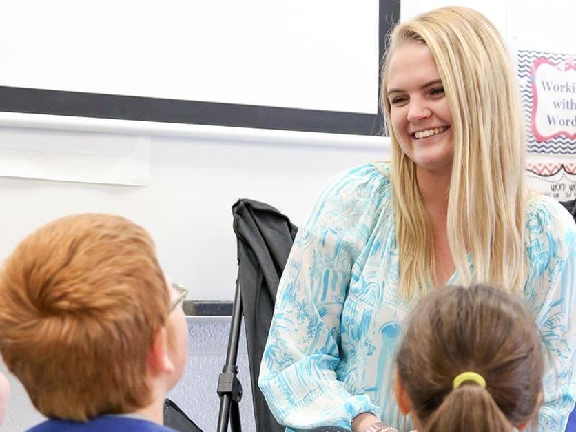 An LR student teacher smiles at children