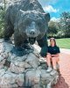 Kristi Hilton poses with the black bear statue on campus