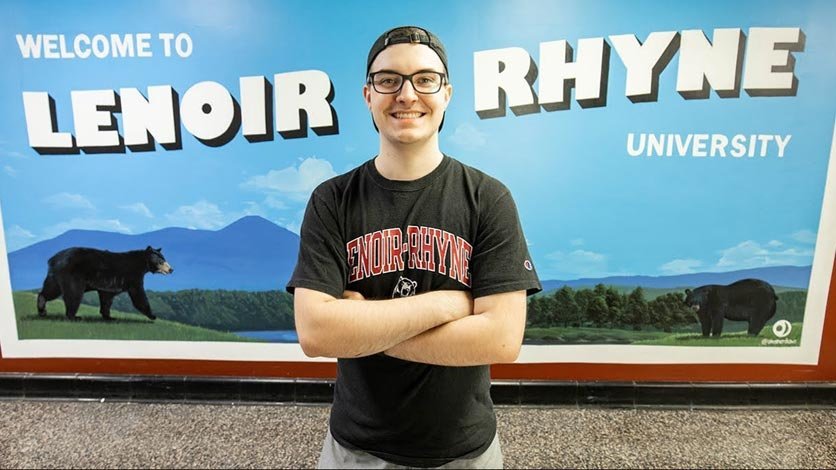 Mason Strother stands in front of his painted Lenoir-Rhyne mural on campus