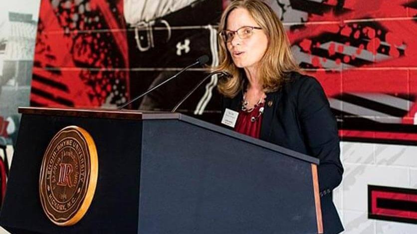 Athletic Director Kim Pate speaks at a podium unveiling the center